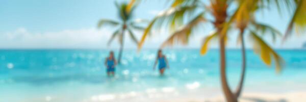 Two people walking in shallow turquoise water under clear skies near palm trees on a sunny beach in tropical paradise photo
