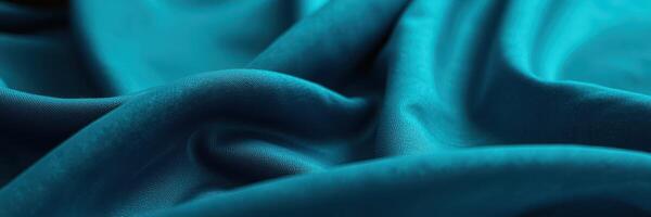 Textured teal fabric draped elegantly showcasing soft folds and smooth surface for design inspiration and creative projects photo