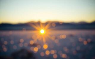 Sunrise illuminating a snowy landscape with blurred details and subtle bokeh effects at dawn photo
