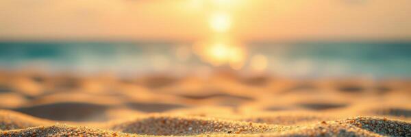 Beautiful sunset over sandy beach with gentle waves reflecting golden light near the shore photo