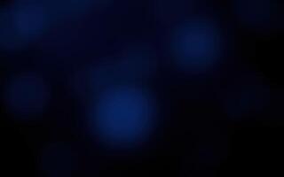 Soft blue orbs float in a dark space creating a mysterious and calming atmosphere at night photo