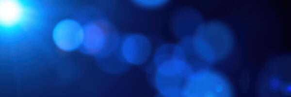 Abstract blue bokeh lights create a dreamy atmosphere in a dimly lit space with an enchanting glow photo