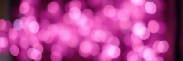 Vibrant pink bokeh lights create a dreamy atmosphere during a festive celebration at night photo