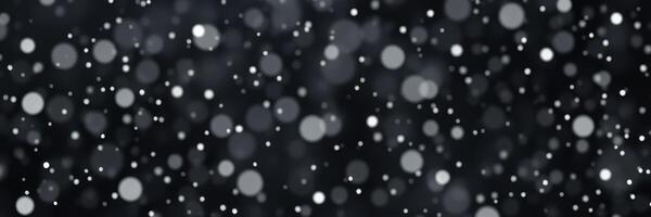 Soft white snowflakes gently fall against a dark backdrop creating a serene winter atmosphere photo