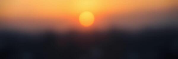 Sunset over the horizon with warm colors illuminating the sky and silhouettes of distant mountains photo