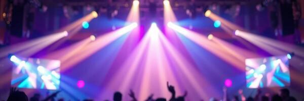 Colorful stage lights illuminate a lively night event with energetic crowd celebration photo