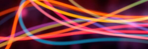 Colorful light trails create vibrant patterns in a dark environment during a nighttime event photo