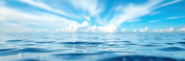 Calm ocean waves reflect a vibrant sky filled with clouds and sunlight during a serene afternoon at sea photo