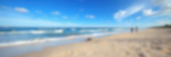 Relaxing beach day with gentle waves and clear blue sky during a sunny afternoon photo