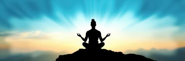 Meditative figure seated on a rocky summit under a colorful sky at sunrise photo