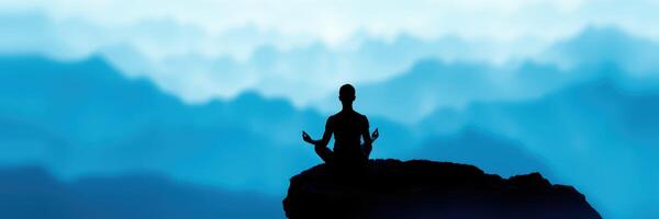 Meditation practice on a rocky outcrop overlooking serene mountains at dawn photo