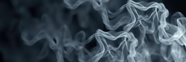 Wispy strands of smoke swirl gracefully in a dimly lit space showcasing fluid movement and texture photo
