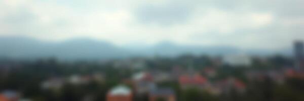 Cityscape view with a soft focus on rooftops and distant mountains under a cloudy sky photo