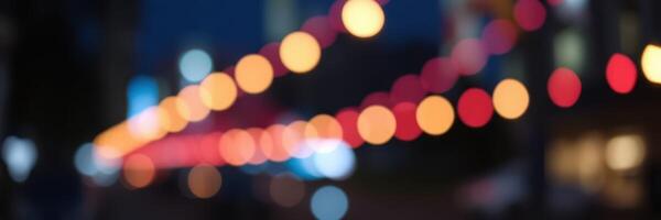 Colorful string lights illuminate a bustling street during evening hours in a vibrant urban setting photo