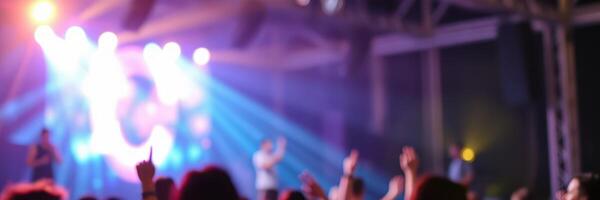 Crowd enjoying a lively concert with vibrant lights and energetic atmosphere at an indoor venue late at night photo