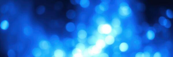 Vibrant blue bokeh light abstract created by reflections and water droplets in a dark environment photo