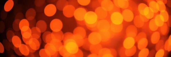 Bright orange bokeh lights create a warm and inviting atmosphere during an evening celebration photo