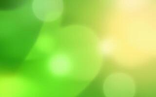 Colorful abstract background featuring soft green and yellow bokeh effects shining through blurred foliage photo