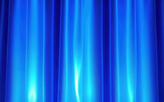 Elegant blue curtain backdrop creating a serene atmosphere for performances in a theater setting photo