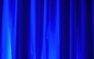 Bright blue curtain backdrop creating a vibrant atmosphere for a performance in an indoor venue photo