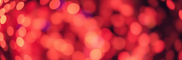 Vibrant red bokeh lights create an enchanting atmosphere at a festive event during the evening photo
