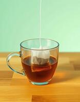 Warm cup of tea steeping with a tea bag hanging over the edge in a cozy kitchen setting photo