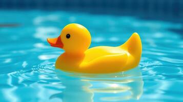Bright yellow rubber duck floating in a clear blue pool during a sunny day photo