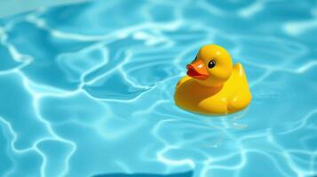 Bright yellow rubber duck floats serenely on clear blue water under sunlight in a summer setting photo
