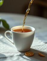 Warm tea being poured into a white cup on a wooden table with citrus slices nearby in natural light photo