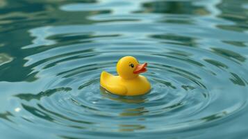 Bright yellow rubber duck floating on calm water in sunny outdoor setting photo