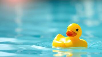 Yellow rubber duck floating on calm blue water, perfect for warm summer days by the pool photo