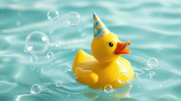 Colorful rubber duck wearing party hat floats among bubbles in a bright blue water setting photo