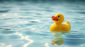 Bright yellow rubber duck floats on calm water surface reflecting light in a serene setting photo