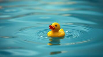 Yellow rubber duck floats serenely in calm blue water during a sunny day photo