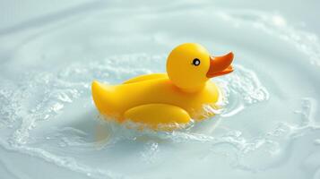 Floating yellow rubber duck in clear water with gentle ripples created by its movement photo