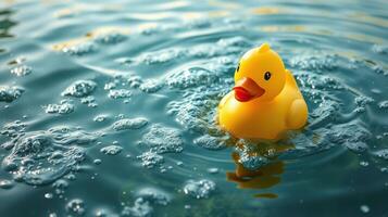 Yellow rubber duck floating on a serene water surface with gentle ripples at midday photo