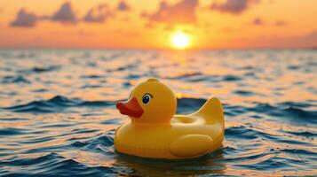 Yellow rubber duck floats peacefully on calm water during a stunning sunset at the beach photo