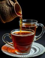 Pouring fragrant tea into clear glass cups placed on a white plate during a cozy afternoon gathering photo