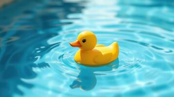 Colorful yellow rubber duck floating in a clear blue swimming pool on a sunny day photo