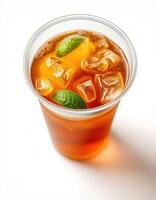 Refreshing iced tea in a clear cup with mint leaves on a white background for a summer drink photo