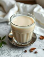 Warm cup of spiced chai tea on a patterned tablecloth with spices and a silver spoon photo