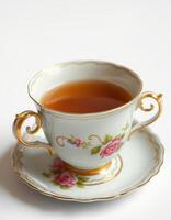 Elegant porcelain cup with tea and floral design, suitable for afternoon tea or formal gatherings photo
