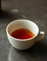 Warm cup of tea on a marble table reflecting cozy indoor ambiance during a quiet afternoon photo