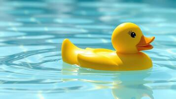 Bright yellow rubber duck floats calmly on the water surface of a serene pool during a sunny day photo