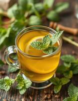 Refreshing herbal tea with mint leaves served in a glass cup on wooden surface photo