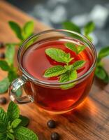 Refreshing herbal tea with mint leaves served in a clear glass cup on a wooden table photo