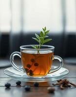 Herbal tea with mint and berries served in a glass cup on a wooden table in a cozy indoor setting photo