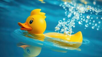 Bright yellow rubber duck floats in clear blue water with bubbles rising around it on a sunny day photo