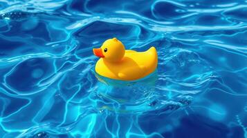 Bright yellow rubber duck floats serenely in clear blue water under sunlight photo