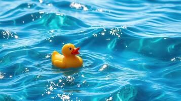 Floating rubber duck in sparkling turquoise water on a sunny day photo